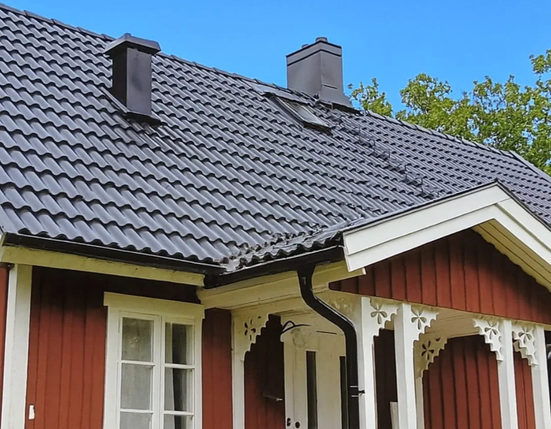 Nylagt mörkt tak på rött trähus