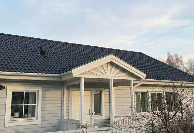 Färdigt hus med svart tak och takkupa efter takomläggningen