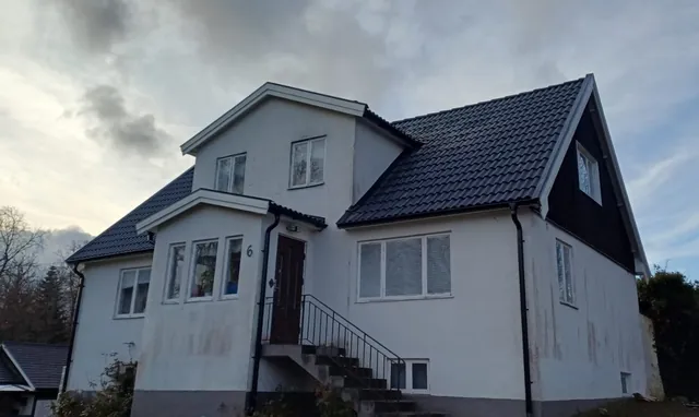 Färdigt svart tak med brant takfall på ett äldre hus i Tyringe